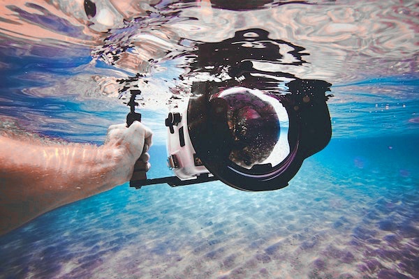 Taucher mit Unterwassergehäuse für spiegelreflex Kamera