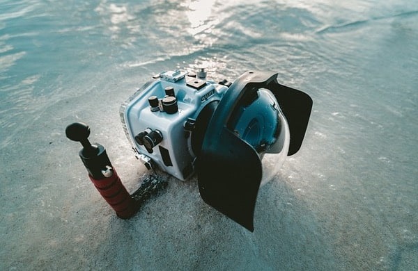 Unterwasserkamera im Unterwassergehaeuse beim Tauchen